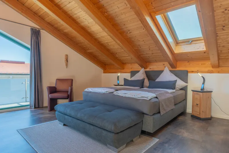 Schlafzimmer 2 mit Boxspringbett, Dachfenster und Balkontür