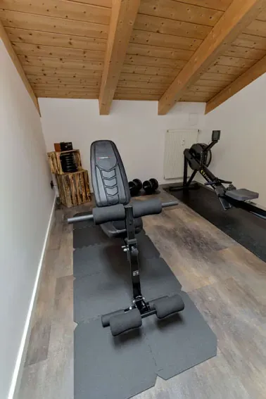 Fitnessraum mit Hantelbank und Rudergerät